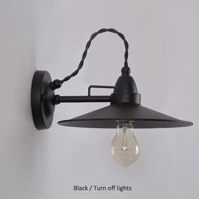 A black metal swing-arm wall sconce with a wide conical shade and a twisted corded arm, shown mounted on a light gray wall. An Edison-style bulb is visible inside, and the text 'Black / Turn off lights' appears at the bottom.