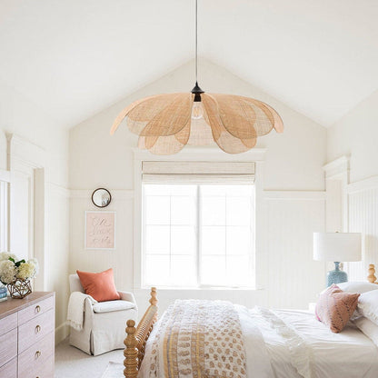 A blooming rattan flower petal pendant light glowing warmly in a serene Japandi living room corner above a cream accent chair.