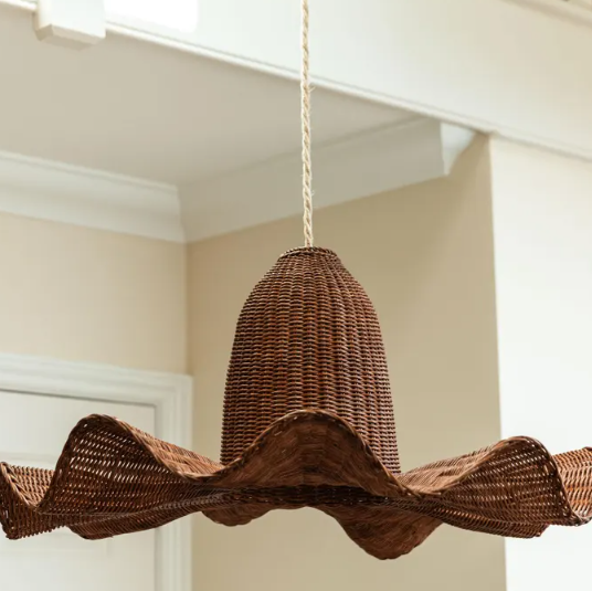 Cozy rattan scalloped pendant light installed in a living room, creating a warm and grounded ambiance.