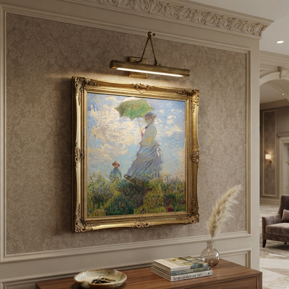 A framed impressionist painting of a woman holding a green parasol hangs on a decorative beige wall above a wooden console table in an elegant interior hallway.