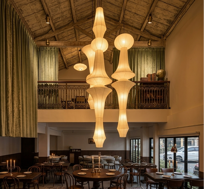 Elegant dining room interior featuring tall, warm-toned paper pendant lights and vintage-style furniture