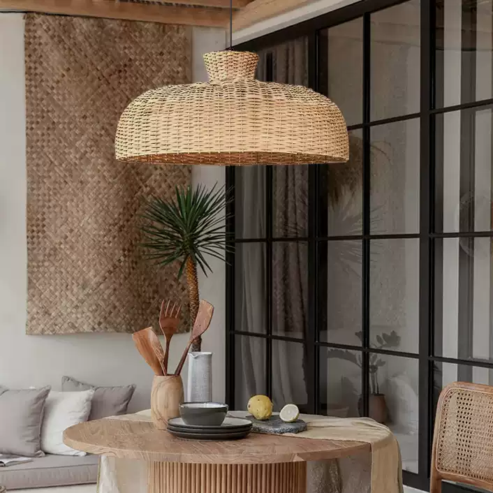 Japandi style hanging lamp with sculptural rattan weave, hanging beautifully over a dining table.