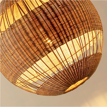 Japandi style hanging lamp with sculptural rattan weave, hanging beautifully over a dining table.