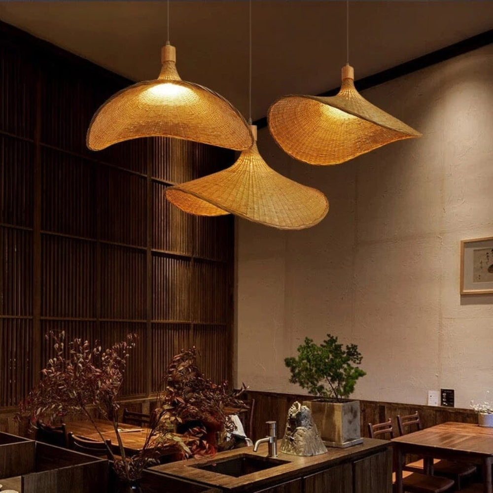 Minimalist wicker hanging lamp with a sleek black cord perfectly styled in a sage green contemporary dining room.