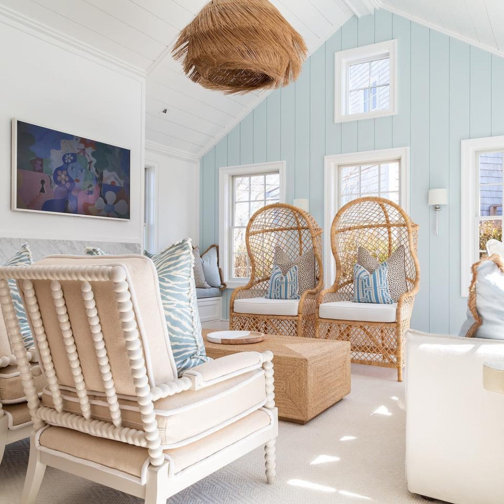 Large statement chandelier with tiered palm fiber fringe layers creating a cozy living room centerpiece.