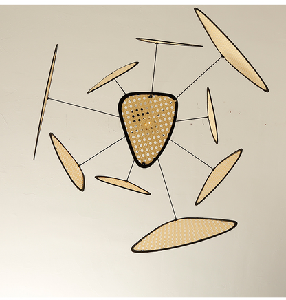 Large boho wicker chandelier with woven cane panels casting soft ambient light over a contemporary dining area.