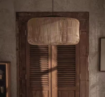 Minimalist capsule-shaped rattan hanging lamp cluster in natural wood tone casting vertical line shadows.