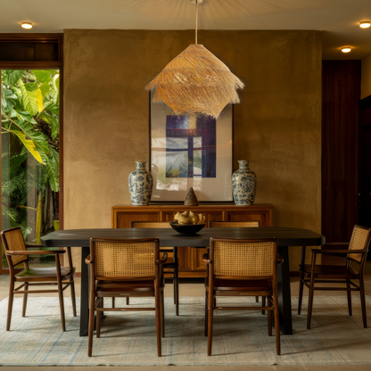 Aesthetic straw hanging light with layered raffia-style thatch fringe over a contemporary dining area.