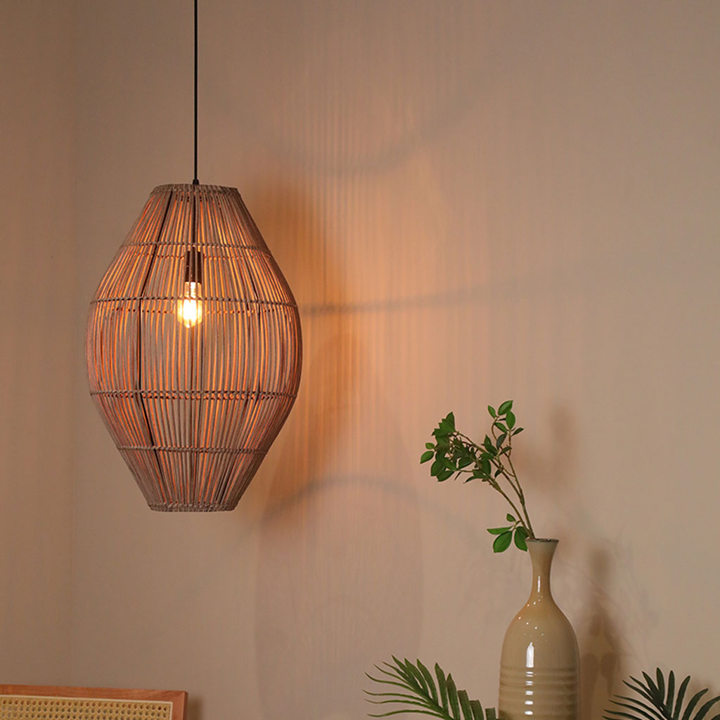 Tear-drop shape straw ceiling chandelier casting a warm, filtered amber glow through a hollow, see-through woven structure.