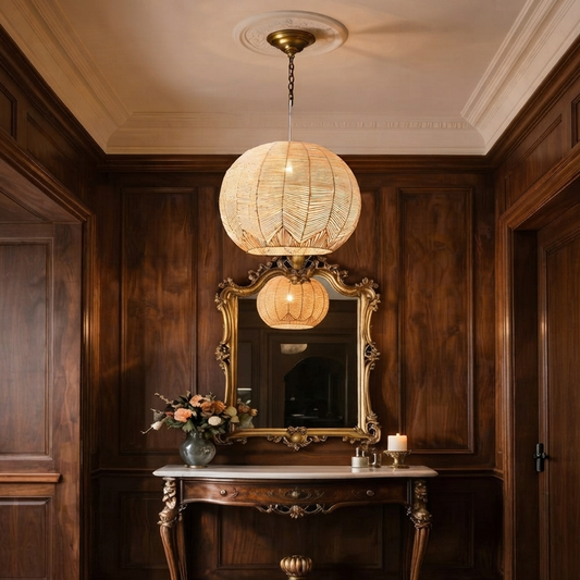 A square, eye-level photograph of a classically styled entryway featuring dark wood paneling, an ornate gilded mirror, and a marble-top console table.