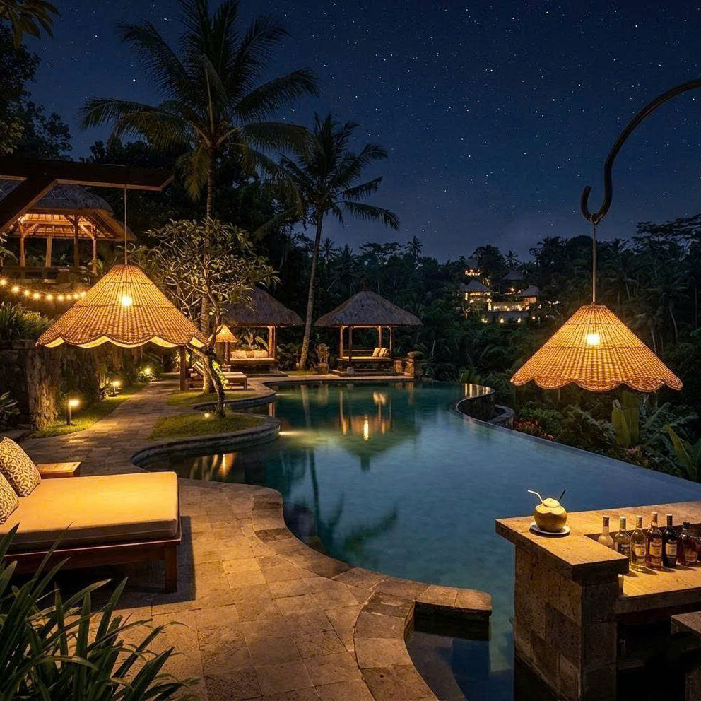 A beautiful rattan pendant light creating a relaxing, luxury atmosphere at a tropical resort pool area, highlighting the natural texture of the fixture against the water.