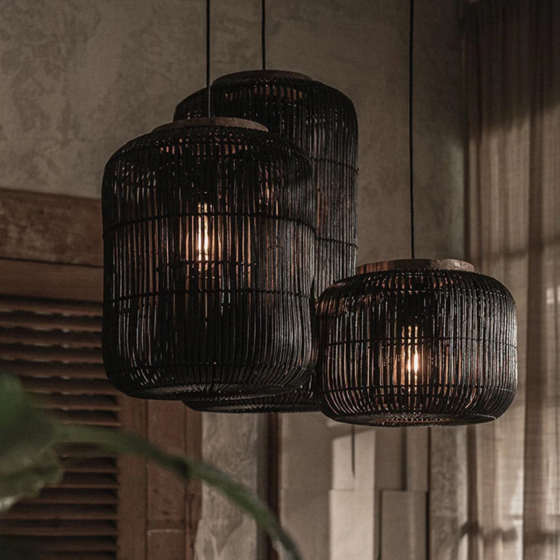 Wabi-Sabi rattan lantern chandelier with vertical bamboo slats hanging in front of a rustic wooden shutter window.