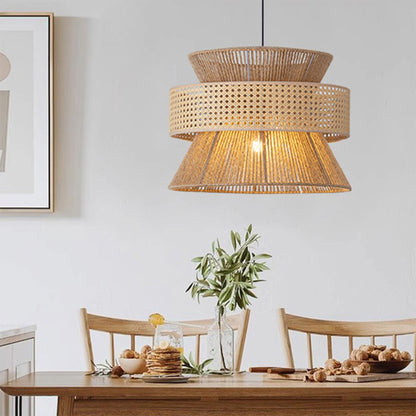 Minimalist natural fiber ceiling fixture with a cluster of three layered shades casting comfortable amber light onto kitchen stools.