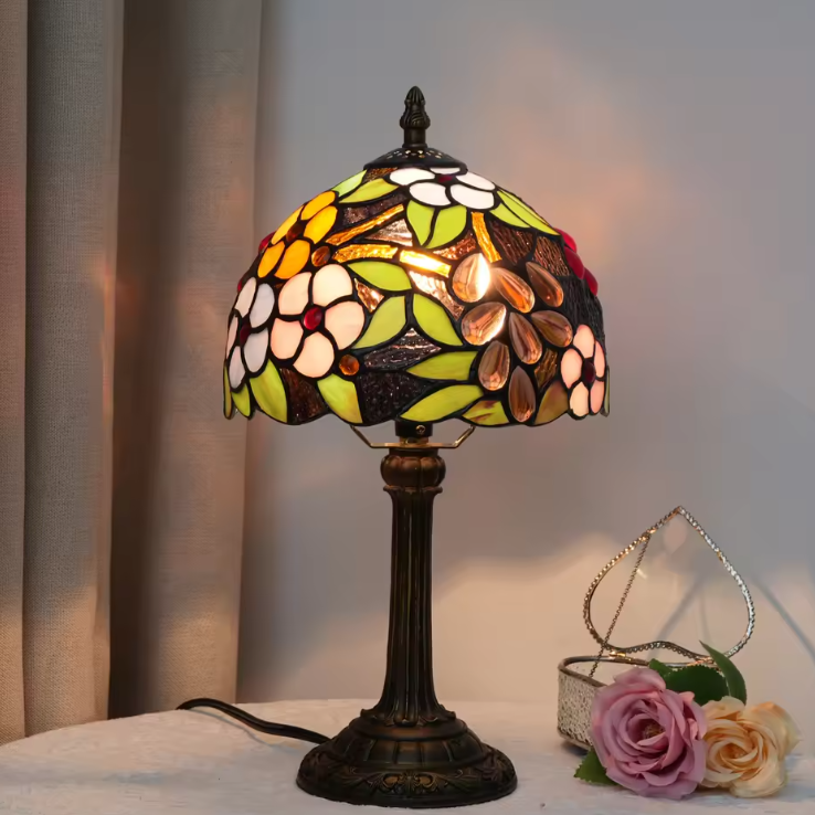 Artistic grape motif Tiffany bedside table lamp casting a warm, colorful glow for cozy master bedroom nightstands.