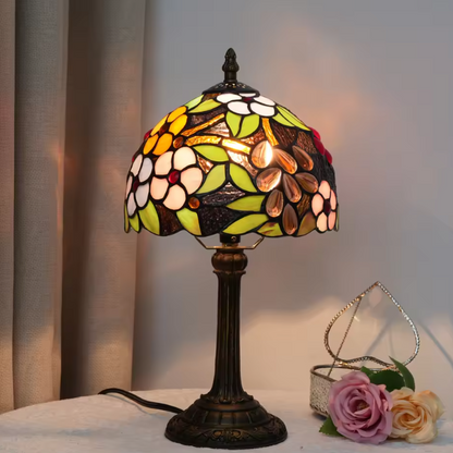Artistic grape motif Tiffany bedside table lamp casting a warm, colorful glow for cozy master bedroom nightstands.