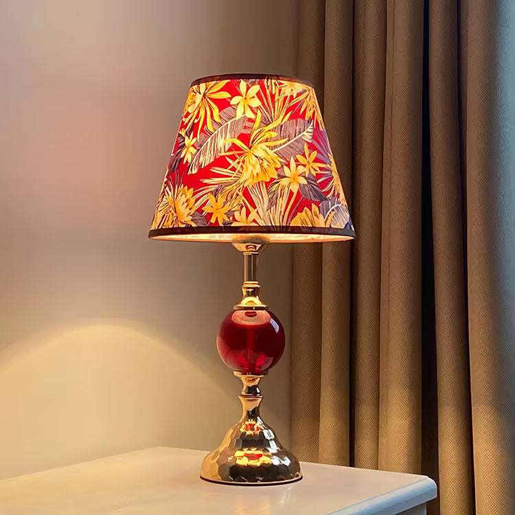 Decorative table lamp with a colorful floral shade on a neutral background