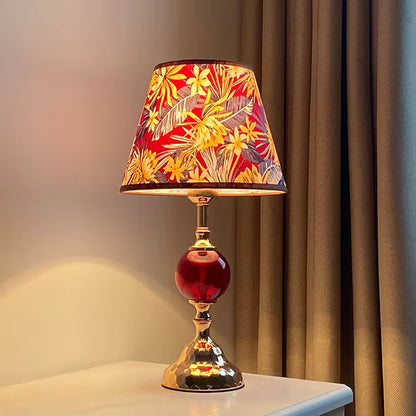 Decorative table lamp with a colorful floral shade on a neutral background