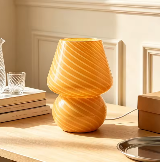 Unique orange striped glass mushroom desk lamp casting a warm, vibrant glow over reading nooks and study tables.