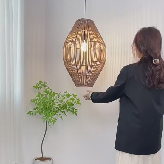 Oval rattan cocoon pendant light side-by-side comparison in turn-off and turn-on modes, showing vertical brown wicker slats.