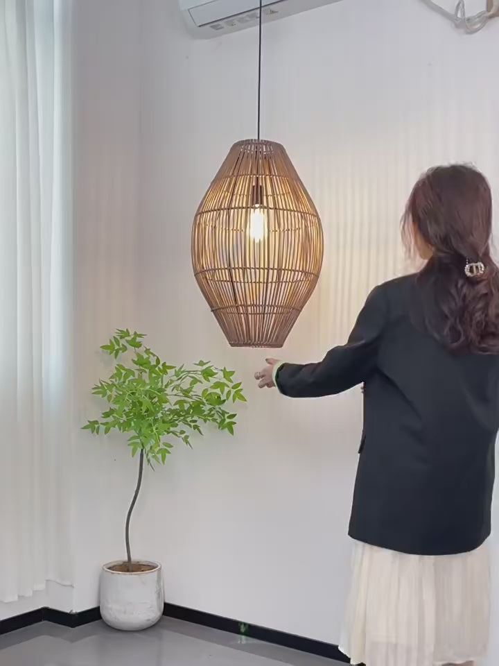 Oval rattan cocoon pendant light side-by-side comparison in turn-off and turn-on modes, showing vertical brown wicker slats.