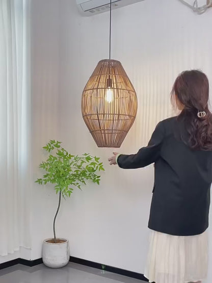 Oval rattan cocoon pendant light side-by-side comparison in turn-off and turn-on modes, showing vertical brown wicker slats.