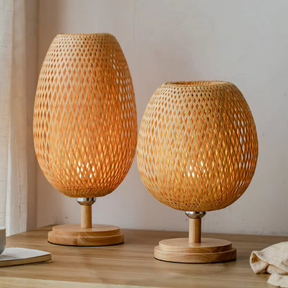 Two woven wooden table lamps on a wooden surface with a neutral background