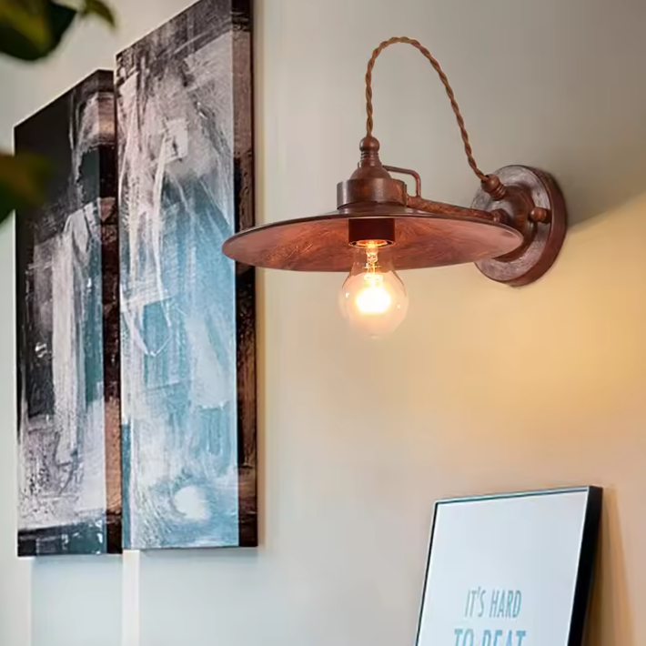 Scandinavian industrial style metal and iron sconce bringing raw simplicity and warmth to a bright entryway.