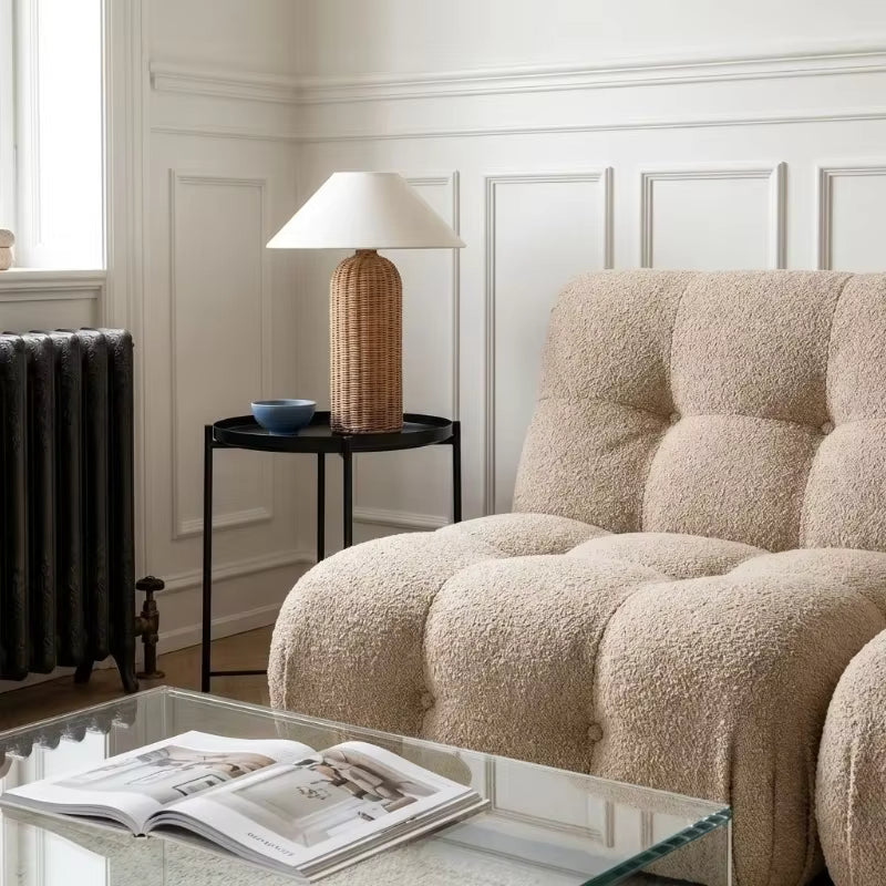 Beige armchair in a room with a side table and lamp
