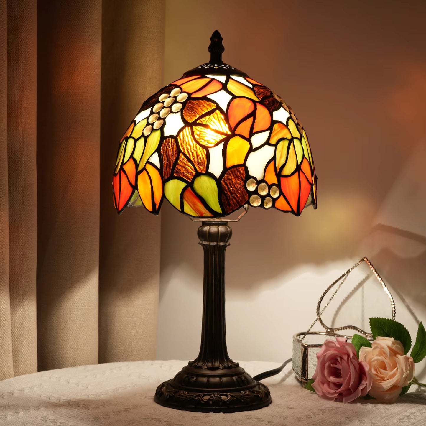 Stunning Tiffany-style stained glass table lamp featuring a vibrant grape cluster design, providing warm ambient lighting for living rooms.