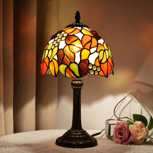 Stunning Tiffany-style stained glass table lamp featuring a vibrant grape cluster design, providing warm ambient lighting for living rooms.