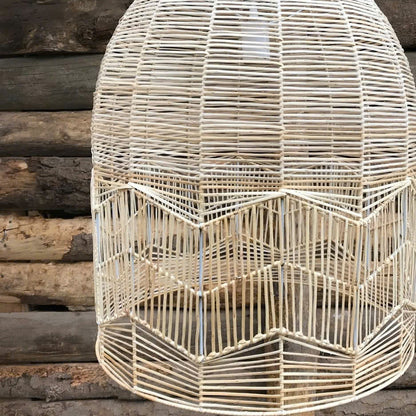 Nordic style woven rattan light fixture with a clean white hanging cord suspended against a soft plain background.